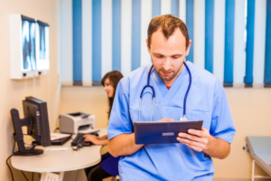 A primary care physician using tablet to make a digital referral