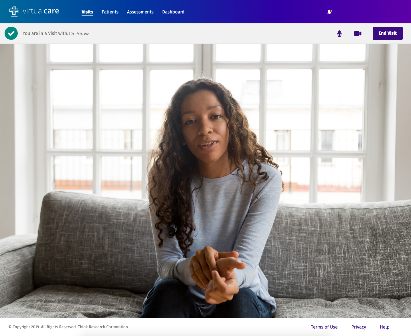 A woman in a grey shirt offering virtual therapy on the VirtualCare platform