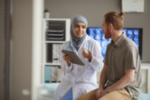 Female doctor holding tablet while talking to patient