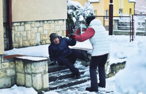 Elderly man slipping on snow-covered stairs