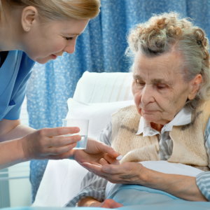Nurse giving medication to senior woman