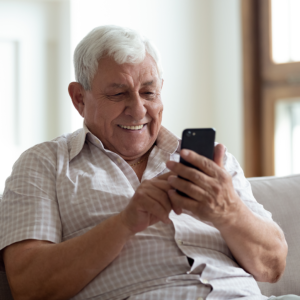 Smiling senior man looking at smartphone