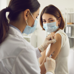 Female doctor giving patient a vaccine in shoulder