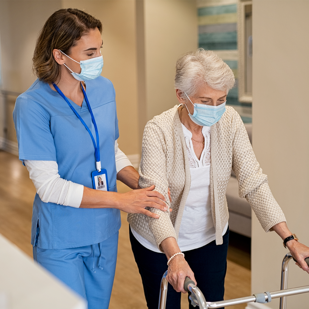 Nurse walking with elderly woman in nursing home